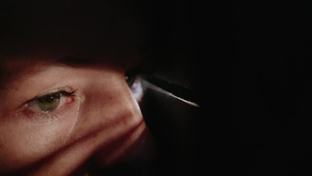 eyes of a hiding woman watching through a crack