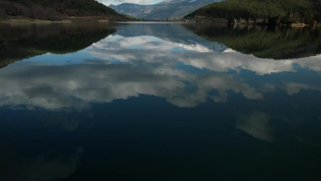 Sky Clouds Reflected on Waters of Lake Doxa, Greece Travel and Tourism Destination between Green Pine Forests in Cinematic Scenic Landscape
