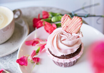 Aesthetic floral cupcake and cup of coffee. Escapism dreamy desserts. Flowers decoration