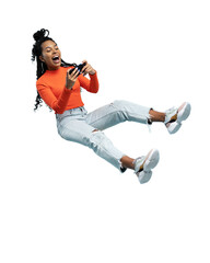 Portrait of an excited young woman sitting on a stool and playing games on mobile phone isolated over transparent background
