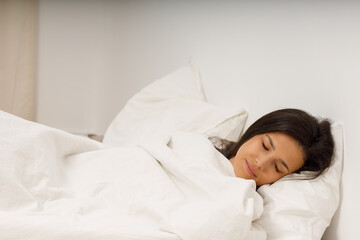 Healthy young woman covering white blanket sleep in bed at bedroom.