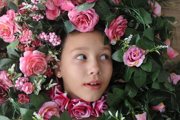 criança feliz com flores rosas ao redor do rosto, conceito de amor a plantas 
