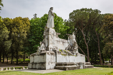 Fototapeta premium TUSCANY, AREZZO – May, 2022: Monument to Francesco Petrarca on the lawn walk inside of Public park in Arezzo. Built in 1928, it is the largest marble complex dedicated to Francesco Petrarca