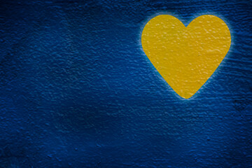 Fototapeta premium yellow heart painted on blue wall