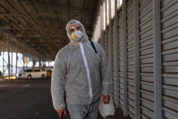 Despair healthcare worker in white covid protective overalls. Tired Male caucasian doctor grabs his...