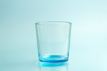 Clear drinking glass isolated on blue background