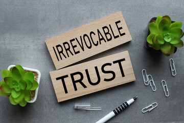 Irrevocable trust two wooden blocks on a gray background. text on wood