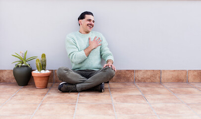 young handsome man gardering and sitting on the floor outdoors