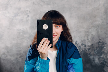 Young sporty woman 80 and 90's style. 90s fashion positive girl with cassette dvd