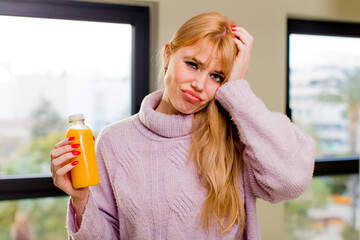 young pretty woman with an orange juice at home interior