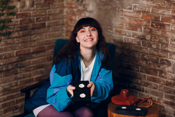 Young sporty woman 80 and 90's style. 90s fashion positive girl sitting home apartment with...