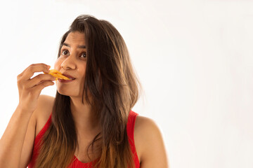 Close-up portrait of woman eating french fries against white background