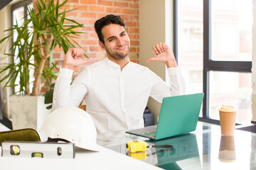 young hispanic man feeling proud, arrogant and confident, looking satisfied and successful,...
