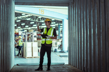 Fototapeta premium Caucasian male worker wearing Hard Hat with clipboard Checks Stock and Inventory in the Retail Warehouse.