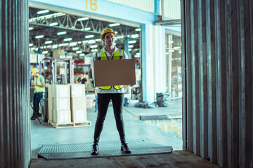 Caucasian male warehouse worker hold cardboard box packaging in warehouse distribution center environment.