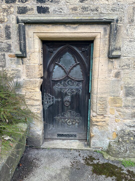 Ancient gothic church arched door with hinges