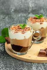 Mousse Three chocolates in a glass decorated with mint. Layered delicious dessert
