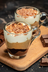 Dessert with three layers chocolates mousse, vanilla, chocolate, creme brulee dessert on a dark background. place for text, top view