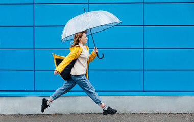 young girl with an umbrella near the big wall