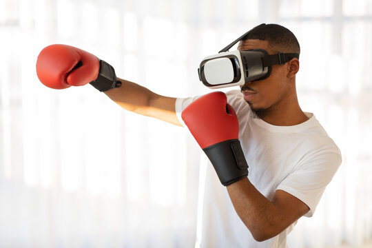 Black guy sportsman in VR headset boxing at home