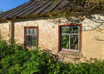 window of an old village house in ukraine with plants inside