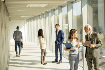 Fototapeta premium Modern business people using digital tablet in the office corridor