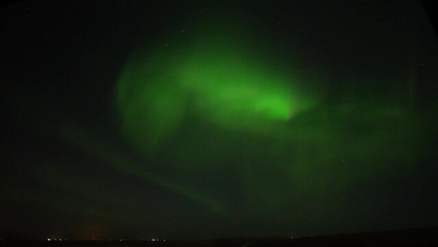 Wide shot of Green Northern Lights at dark sky moving