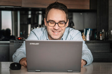 Happy confident businessman, entrepreneur, small business owner portrait at home office workplace. handsome freelance employee, student using laptop computer, smiling