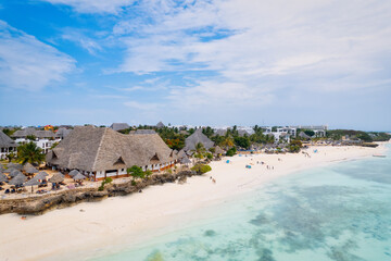 The picturesque Nungwi beach in Zanzibar, Tanzania is showcased in a toned aerial view image, highlighting the luxury resort and turquoise ocean waters.