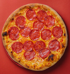 Fresh tasty pizza with pepperoni on red background