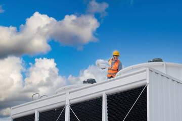 Industry engineer under checking the industry cooling tower air conditioner is water cooling tower air chiller HVAC of large industrial building to control air system.