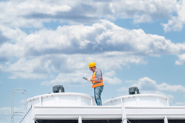 Industry engineer under checking the industry cooling tower air conditioner is water cooling tower...