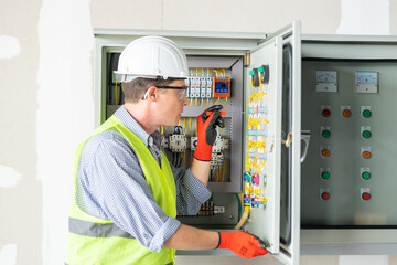 Electrician installing electrical wires and multimeter fuse switch box in hands of electrician detail