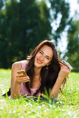 Happy beautiful brunette girl calling by phone