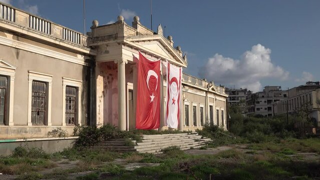 Turkish and Northern Cypriotic flag draped on entrance of former government building in Varosha, a long abandoned neighborhood in Famagusta, Cyprus