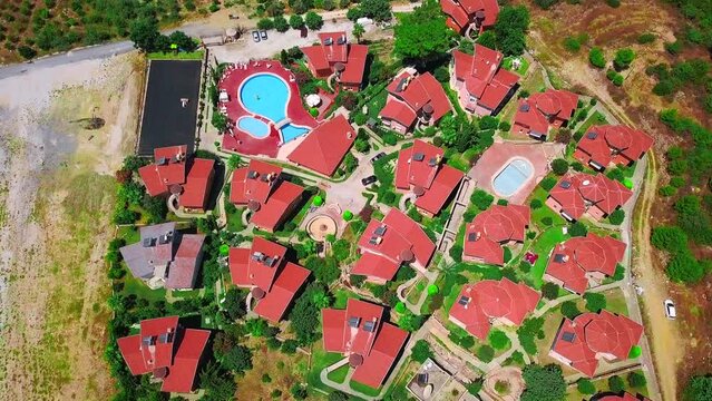 Aerial top view of small villas and open air swimming pool. Clip. Concept of summer holidays and tourism.
