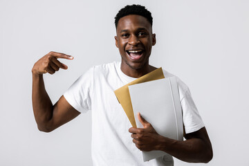 Happy delighted handsome attractive young guy man in white t-shirt with wooden folders in hands...