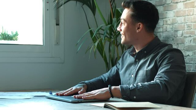 One portrait of young millennial male working at home with laptop on the table finishing homework or work and leaving to go home