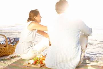 It doesnt get more romantic than this. A loving couple watching the sunset while enjoying a picnic...