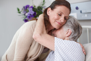 Im so glad. An affectionate daughter embracing her sick mother in the hospital.