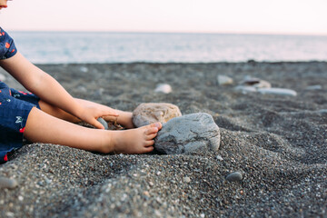 Fototapeta na wymiar Little cute child girl playing on the seashore in summer