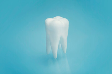 clean tooth model on blue background. treatment of toothache. he concept of dentistry.