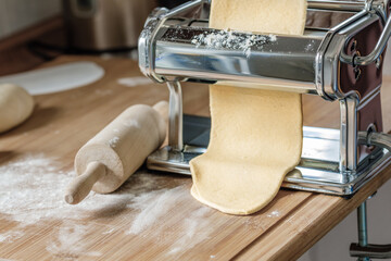 Pasta in der Küche selbst gemacht mit einer Nudelmaschine
