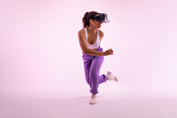 Joyful black woman enjoying virtual reality experience in modern vr headset, fit young lady...