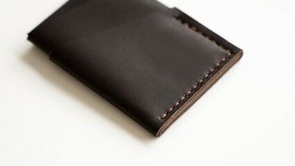 Brown empty men's business handmade genuine leather card holder with isolated on white background. Selective focus, copy space, close up.