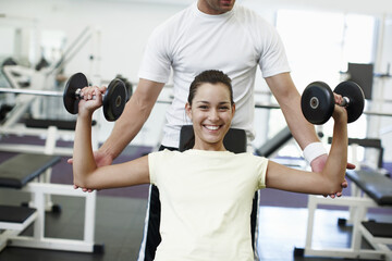 My personal trainer is great. Cropped portrait of an attractive young woman weight training with...