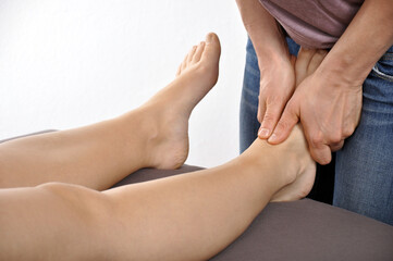 Osteopath and physiotherapist treating patient's feet