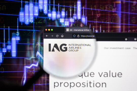 IAG International Airlines Group company logo on a website with blurry stock market developments in the background, seen on a computer screen through a magnifying glass	