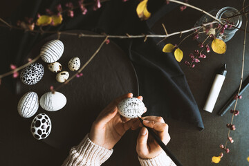 DIY hand painted black and white easter eggs. Unrecognizable person hand painting easter eggs.