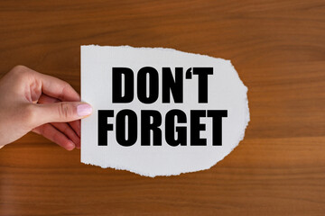 Don't forget. Woman hand holds a piece of paper with a note, don't forget. Advice, reminder, mnemonic, memories and message.
